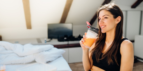 Frau stärkt ihr Immunsystem mit einem vitaminreichen Getränk nach einem Workout